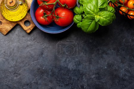 Téléchargez les photos : Ingrédients pour la cuisine. Cuisine italienne. Tomates, basilic et huile d'olive. Pose plate avec espace de copie - en image libre de droit