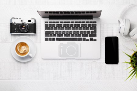 Téléchargez les photos : Table de bureau avec ordinateur portable, tasse de café et fournitures. Vue de dessus. Pose plate - en image libre de droit