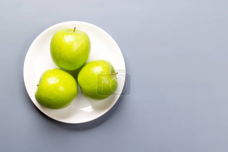 Téléchargez les photos : Trois pommes dans l'assiette. Pose plate avec espace de copie - en image libre de droit
