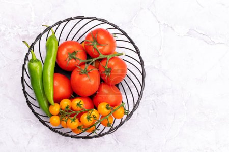 Téléchargez les photos : Légumes frais de jardin dans le panier. Tomates et poivre. Cuisine italienne. Pose plate avec espace de copie - en image libre de droit