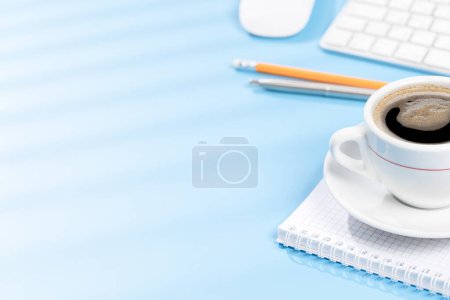 Foto de Escritorio de oficina de vista superior con teclado, suministros de oficina y café. Espacio de trabajo con luz soleada y espacio de copia - Imagen libre de derechos