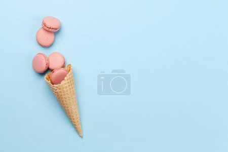 Photo for Various macaroon cookies in ice cream cones. Flat lay on blue background with copy space - Royalty Free Image