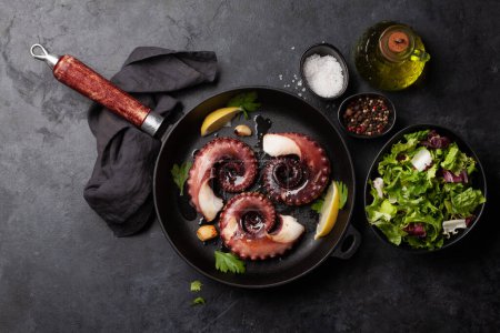 Photo for Grilled octopus with herbs and spices on frying pan. Top view flat lay - Royalty Free Image