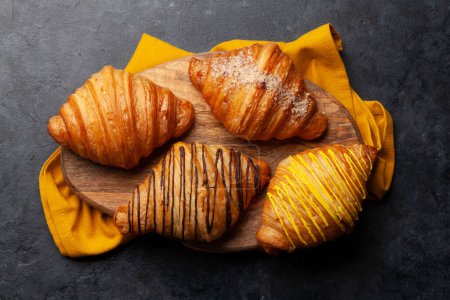 Foto de Varios croissants en tablero de madera. Desayuno francés. Vista superior plano laico - Imagen libre de derechos