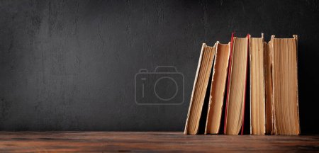 Photo for Old books on wooden table and blackboard for copy space. School and education template - Royalty Free Image