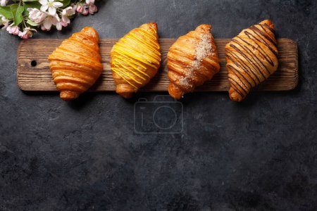 Foto de Varios croissants en tablero de madera. Desayuno francés. Vista superior plano con espacio de copia - Imagen libre de derechos