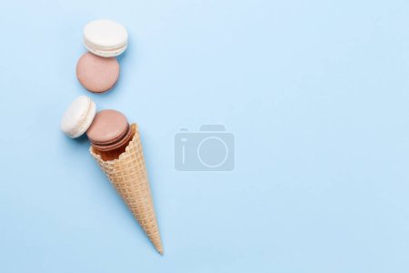 Photo for Various macaroon cookies in ice cream cone. Flat lay on blue background with copy space - Royalty Free Image