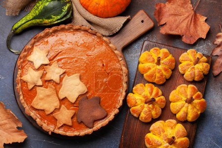 Photo for Homemade pumpkin pie, pumpkin look muffins and various pumpkins. Top view flat lay - Royalty Free Image