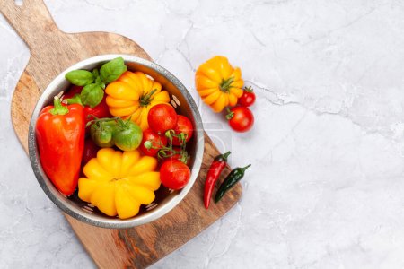 Foto de Varios coloridos tomates de jardín y pimientos. Verduras frescas y especias. Vista superior plano con espacio de copia - Imagen libre de derechos
