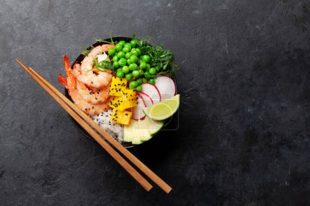 Photo for Poke bowl with shrimps, avocado and mango. Traditional hawaiian meal. Top view flat lay with copy space - Royalty Free Image