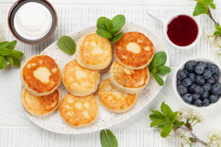 Photo for Cottage pancakes with berry jam, sour cream and berries. Top view flat lay - Royalty Free Image