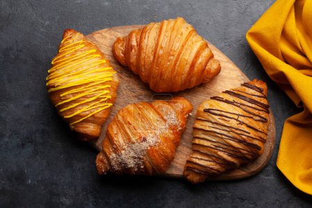Foto de Varios croissants en tablero de madera. Desayuno francés. Vista superior plano laico - Imagen libre de derechos