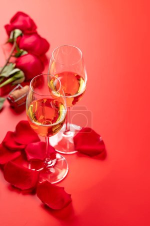 Foto de Tarjeta de San Valentín con champán y rosas. Sobre fondo rojo con espacio para tus saludos - Imagen libre de derechos