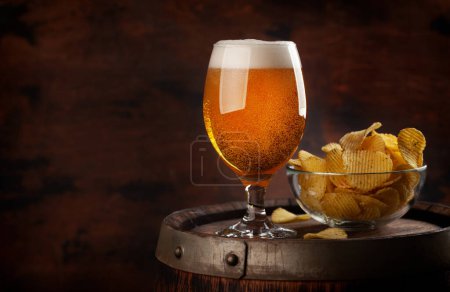 Foto de Copa de cerveza y papas fritas en barril de madera. Con espacio de copia - Imagen libre de derechos