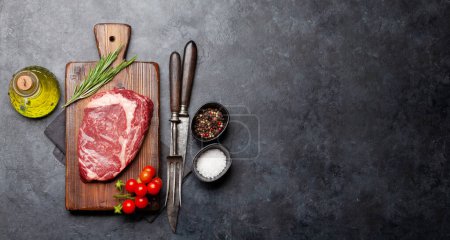Téléchargez les photos : Steak de côtelette cru sur planche à découper. Cuisine barbecue. Pose plate avec espace de copie - en image libre de droit
