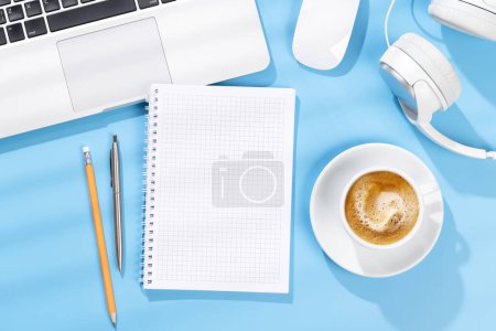 Photo for Top view business office desk with blank notepad, office supplies and coffee. Flat lay workspace with sunny light and copy space - Royalty Free Image
