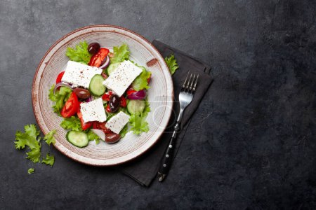 Foto de Ensalada griega con verduras frescas y queso feta. Piso con espacio de copia - Imagen libre de derechos