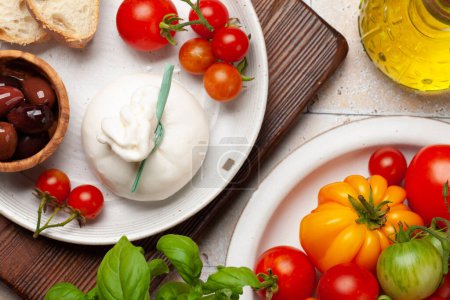 Téléchargez les photos : Fromage burrata, tomates et olives variées. Cuisine italienne. Pose plate - en image libre de droit