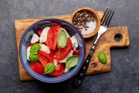 Photo for Caprese salad with ripe tomatoes, mozzarella cheese and garden basil. Flat lay - Royalty Free Image