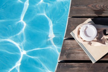 Téléchargez les photos : Réserver et café près de la piscine. Vacances d'été. Pose plate - en image libre de droit