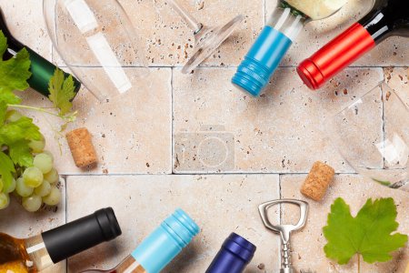 Photo for Various wine bottles, glasses and corkscrews on stone table. Flat lay with copy space - Royalty Free Image