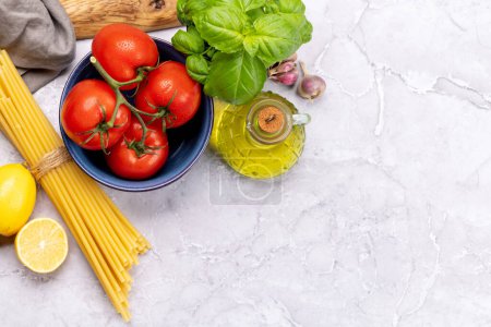 Photo for Ingredients for cooking. Italian cuisine. Pasta, tomatoes, basil. Flat lay with copy space - Royalty Free Image