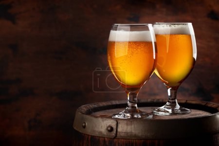 Foto de Dos vasos de cerveza en barril de madera. Con espacio de copia - Imagen libre de derechos