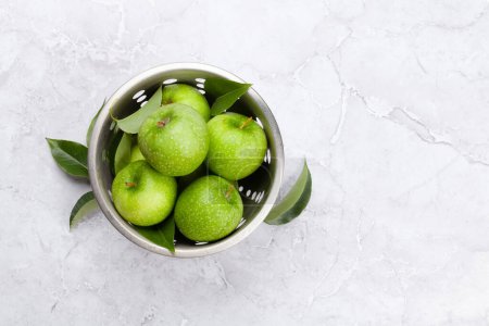 Photo for Fresh green apples in colander on stone table. Flat lay with copy space - Royalty Free Image