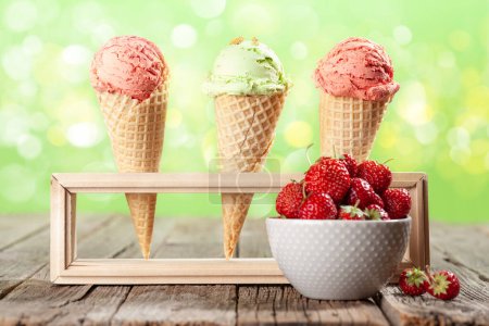 Foto de Varios helados en conos de gofre y tazón con fresa - Imagen libre de derechos