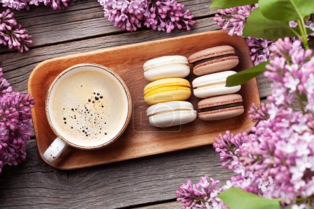 Téléchargez les photos : Biscuits au macaron et café. Sur table en bois avec fleurs lilas. Vue du dessus plat lay - en image libre de droit