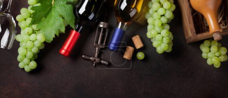 Foto de Botellas de vino y uvas en mesa de piedra. Vista superior plano laico - Imagen libre de derechos
