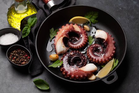 Photo for Grilled octopus with herbs and spices on frying pan - Royalty Free Image