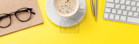 Photo for Office yellow workplace backdrop with coffee cup, supplies and computer. Flat lay - Royalty Free Image