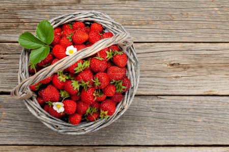 Photo for Ripe strawberries in basket on wooden table. Top view flat lay with copy space - Royalty Free Image