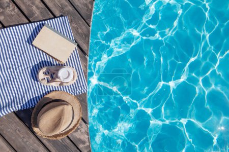 Téléchargez les photos : Livre, café et chapeau de soleil près de la piscine. Vacances d'été. Pose plate - en image libre de droit
