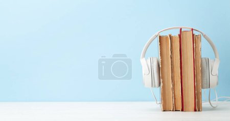 Photo for Old books and headphones on wooden table and copy space. Audiobooks and education template - Royalty Free Image