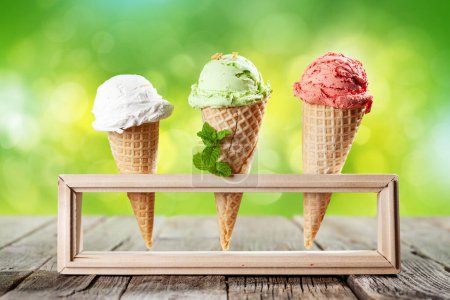 Téléchargez les photos : Différentes glaces dans des cônes de gaufres. Glace aux fraises, pistaches et vanille - en image libre de droit