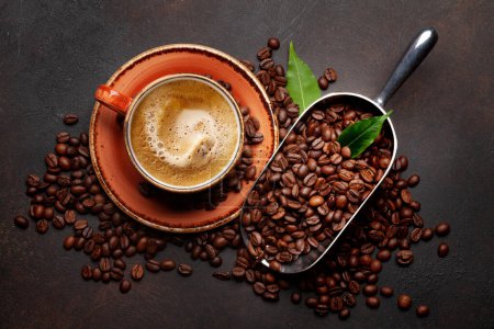 Foto de Granos de café tostados en cucharada y taza de espresso. Piso puesto en la mesa de piedra - Imagen libre de derechos