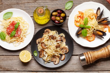 Téléchargez les photos : Différentes pâtes italiennes. Fruits de mer, champignons et sauce tomate pâtes, spaghettis bolognaise. Vue du dessus plat lay - en image libre de droit