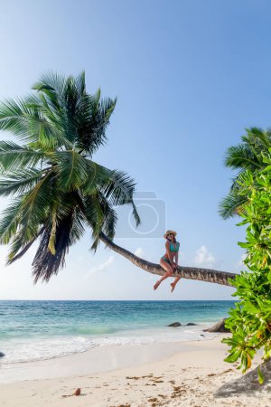 Foto de Chica joven en la palma en la playa del mar. Vacaciones de verano - Imagen libre de derechos