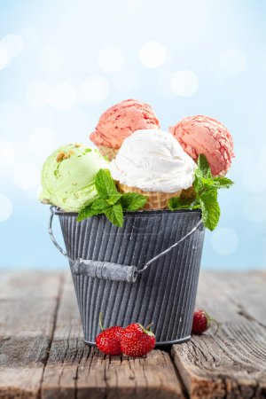 Foto de Varios helados en conos de gofre. Helado de fresa, pistacho y vainilla - Imagen libre de derechos