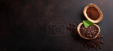 Foto de Granos de café tostados y polvo molido sobre fondo de piedra. Piso con espacio de copia para su texto - Imagen libre de derechos