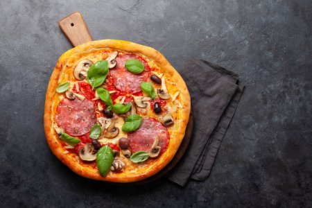 Foto de Cocina italiana. Pizza de pepperoni. Piso puesto en la mesa de piedra con espacio de copia - Imagen libre de derechos