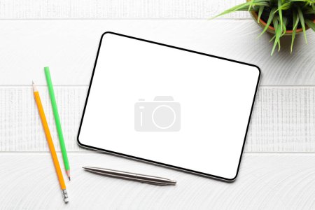 Téléchargez les photos : Tablette avec écran blanc sur le bureau et les fournitures de bureau. Vue du dessus plat avec espace de copie - en image libre de droit