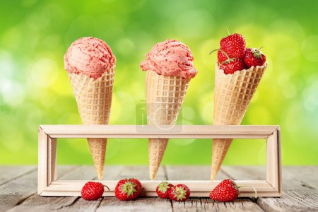Téléchargez les photos : Glace aux fraises en cônes de gaufres sur table de jardin - en image libre de droit