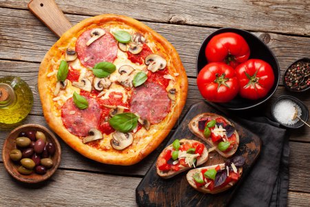 Téléchargez les photos : Cuisine italienne. Pizza Pepperoni et toasts. Poser à plat sur une table en bois - en image libre de droit