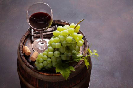Téléchargez les photos : Raisin blanc, tire-bouchon vintage et verre à vin rouge sur vieux tonneau de vin en bois. Avec espace de copie - en image libre de droit