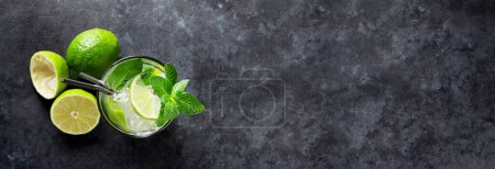 Photo for Mojito cocktail on dark stone wide table. Flat lay with copy space for your text - Royalty Free Image