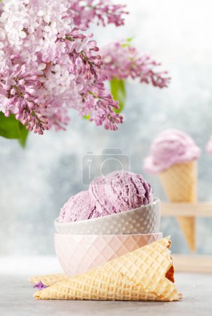 Foto de Helado de bayas en conos de gofre y flores lila - Imagen libre de derechos