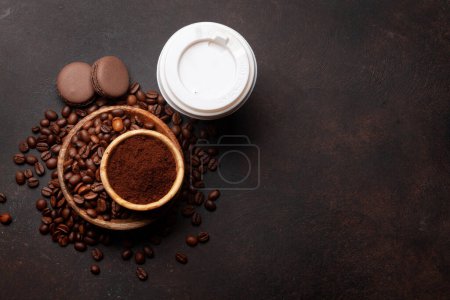 Foto de Café fresco en taza para llevar, granos de café tostados y café molido. Vista superior plano con espacio de copia - Imagen libre de derechos